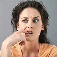 Woman with a concerned expression and hand to mouth, reflecting indecision in consumer decision-making processes related to fast and slow thinking.