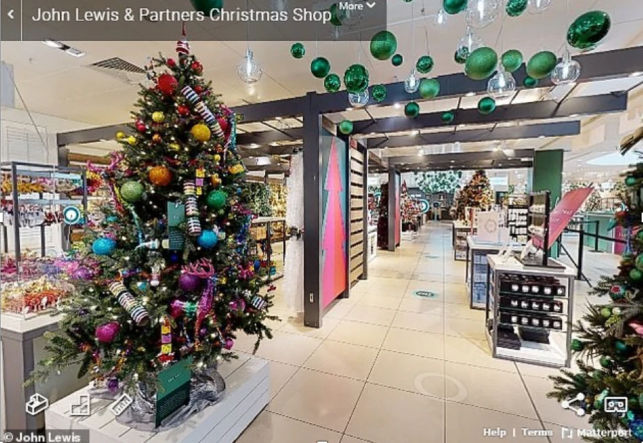 John Lewis Christmas shop interior featuring a decorated Christmas tree with colorful ornaments, festive decorations, and a virtual tour setup showcasing holiday displays.
