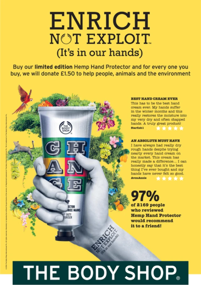 Hemp Hand Protector tube with "ENRICH NOT EXPLOIT" slogan, surrounded by vibrant flowers and greenery, showcasing The Body Shop's commitment to ethical practices and environmental support.
