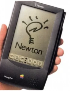Hand holding Apple Newton PDA with light bulb illustration and 'Newton' branding, representing a notable product failure in new product development.