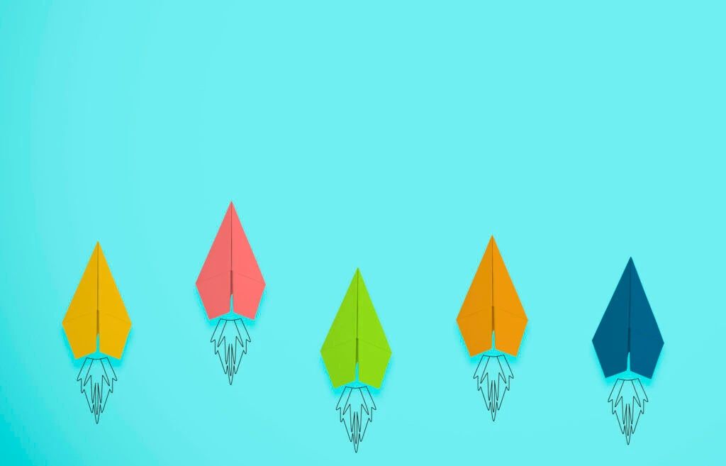 Colorful paper rockets in a row against a light blue background, symbolizing brand growth and performance measurement.